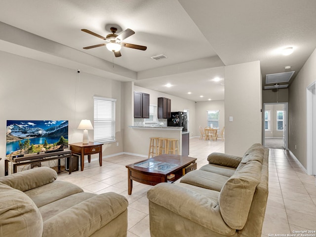 tiled living room featuring ceiling fan and a textured ceiling