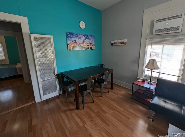 dining area with hardwood / wood-style flooring and an AC wall unit