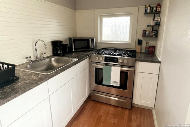 kitchen with sink, white cabinetry, stainless steel appliances, and dark hardwood / wood-style flooring