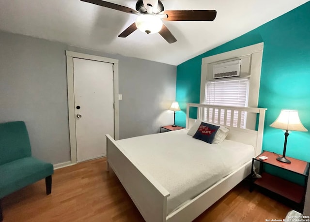 bedroom with ceiling fan, wood-type flooring, and vaulted ceiling