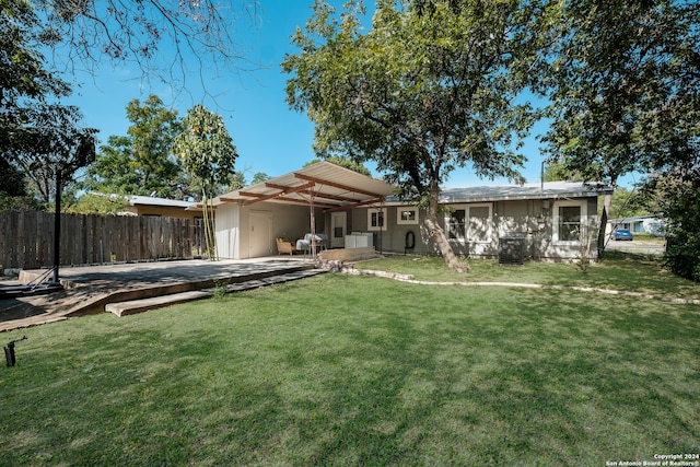 back of house featuring central air condition unit, a patio area, and a yard