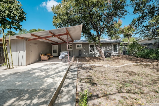 rear view of house featuring a patio area and a carport