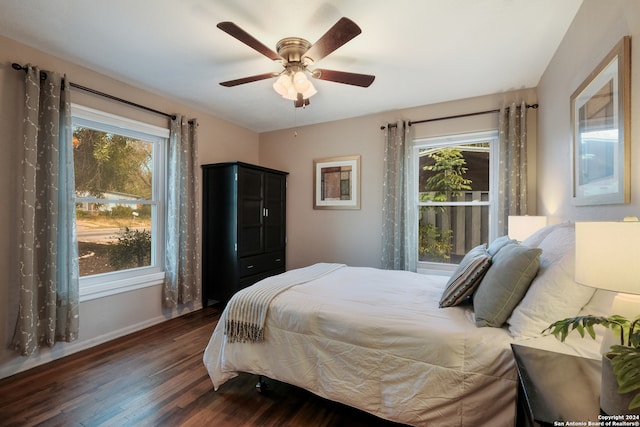 bedroom featuring multiple windows, dark hardwood / wood-style floors, and ceiling fan