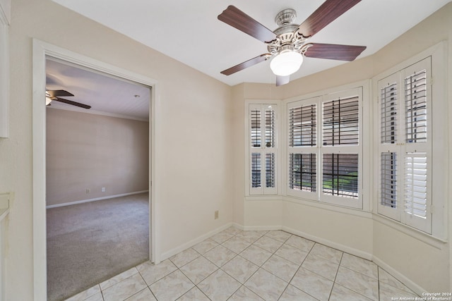 spare room featuring crown molding, ceiling fan, and light tile patterned floors