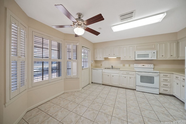 kitchen featuring white appliances, white cabinetry, light tile patterned floors, and sink