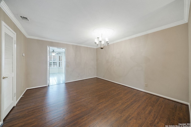 empty room featuring crown molding, ceiling fan with notable chandelier, and dark hardwood / wood-style flooring