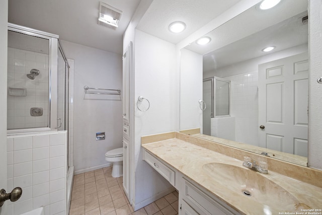 bathroom with a textured ceiling, toilet, a shower with shower door, vanity, and tile patterned flooring