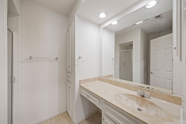 bathroom with vanity, a shower with shower door, and tile patterned floors