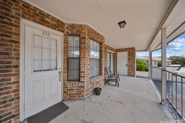 view of exterior entry featuring covered porch