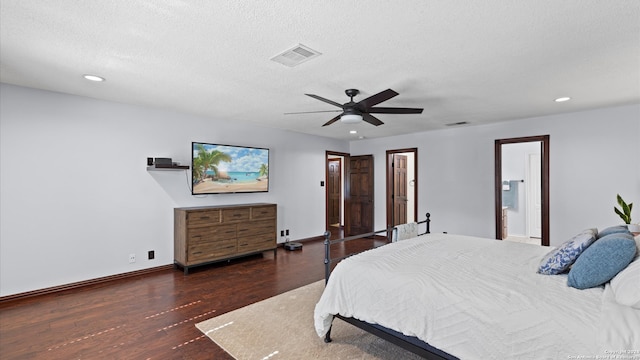 bedroom featuring dark hardwood / wood-style flooring, a textured ceiling, ensuite bathroom, and ceiling fan