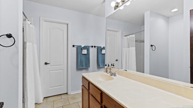 bathroom with vanity, tile patterned floors, and a textured ceiling