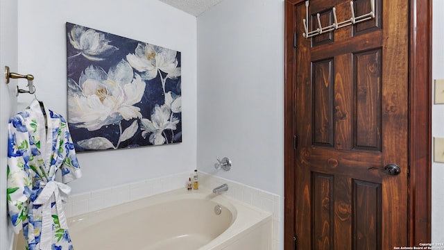 bathroom with a textured ceiling and a washtub