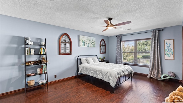 bedroom featuring dark wood-type flooring, a textured ceiling, and ceiling fan