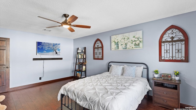 bedroom with ceiling fan, a textured ceiling, and dark hardwood / wood-style flooring