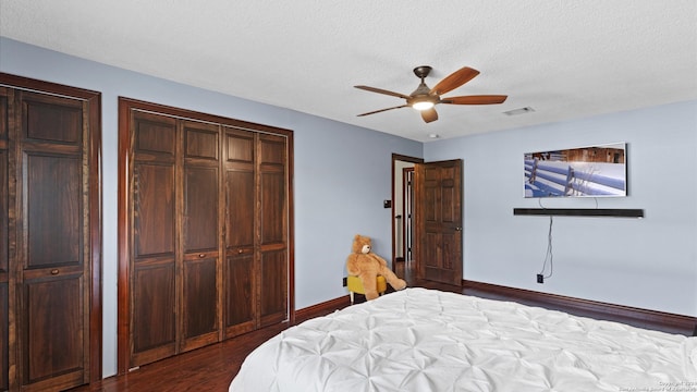 bedroom with dark wood-type flooring, ceiling fan, and a textured ceiling