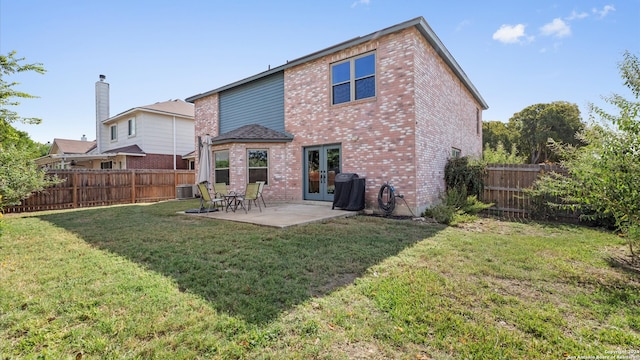 back of property with a patio area and a yard