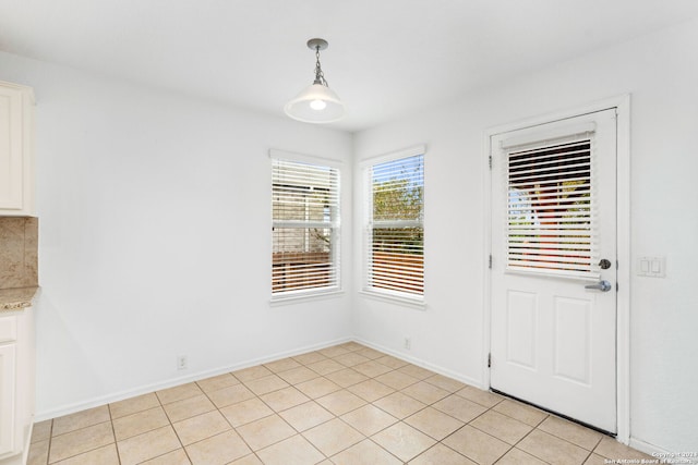 unfurnished dining area featuring light tile patterned floors