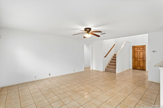 tiled empty room featuring ceiling fan