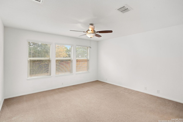 carpeted spare room with ceiling fan