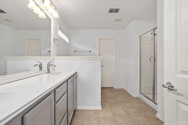 bathroom featuring a shower with door, vanity, and tile patterned flooring