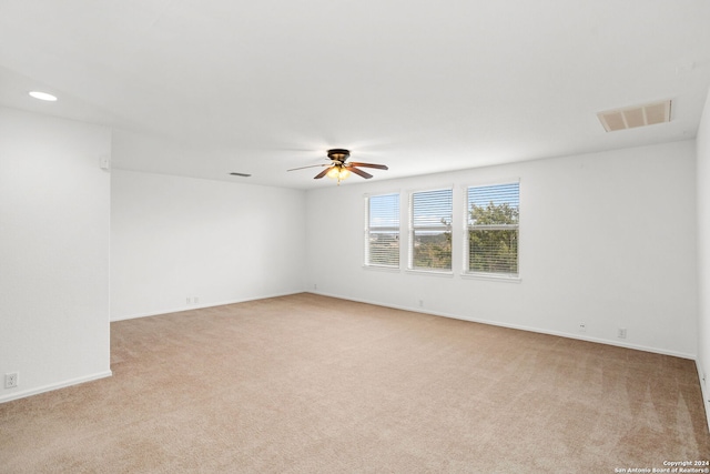 carpeted spare room with ceiling fan