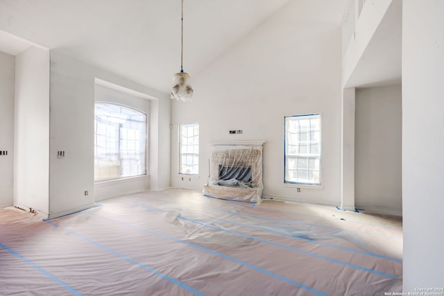 unfurnished living room with high vaulted ceiling