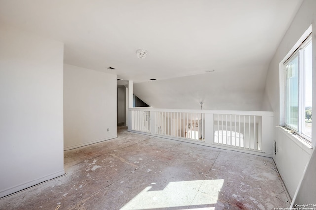 unfurnished room with lofted ceiling