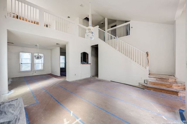 unfurnished living room featuring a high ceiling and an inviting chandelier