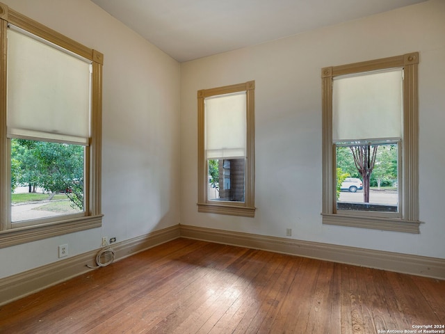 spare room with hardwood / wood-style flooring and a healthy amount of sunlight