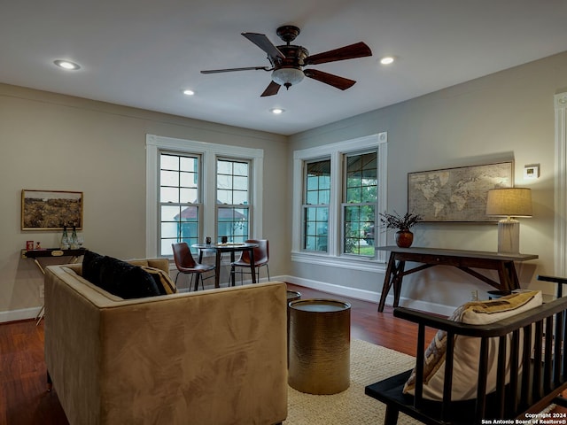 living room with plenty of natural light, ceiling fan, and dark hardwood / wood-style flooring