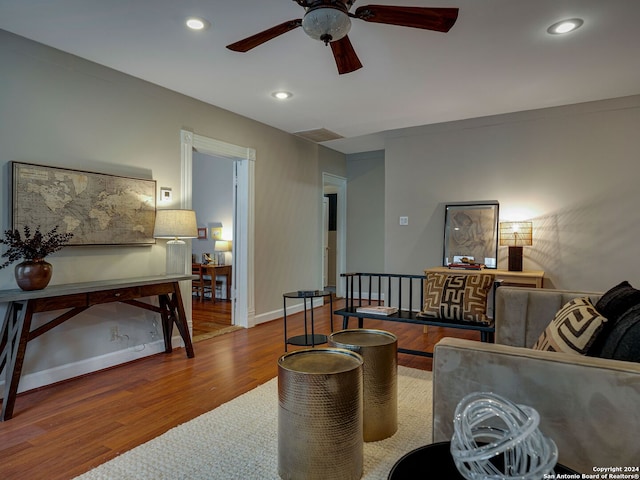 living room featuring hardwood / wood-style floors and ceiling fan