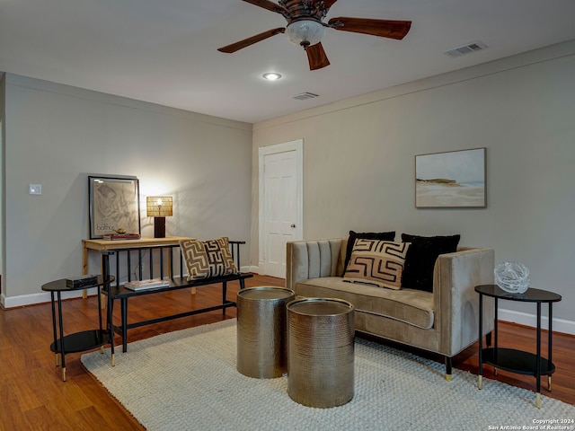 living room featuring ceiling fan, wood-type flooring, and ornamental molding