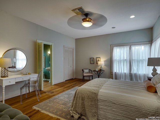 bedroom featuring hardwood / wood-style flooring, ceiling fan, and multiple windows