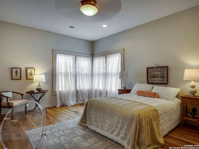 bedroom with light hardwood / wood-style floors and ceiling fan