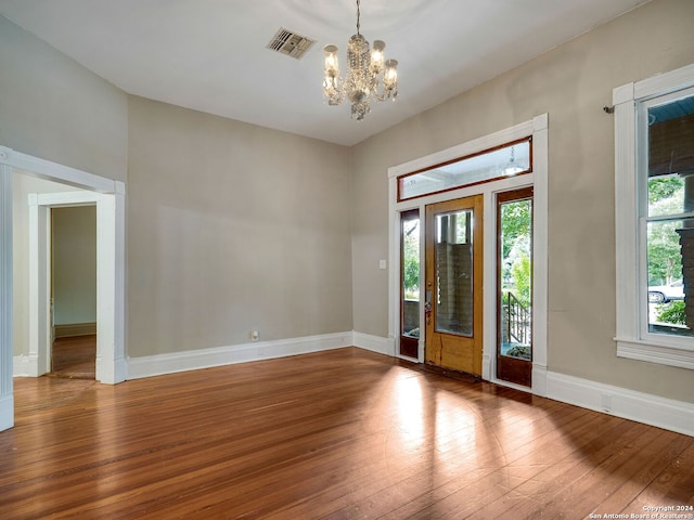 entryway with wood-type flooring and a chandelier