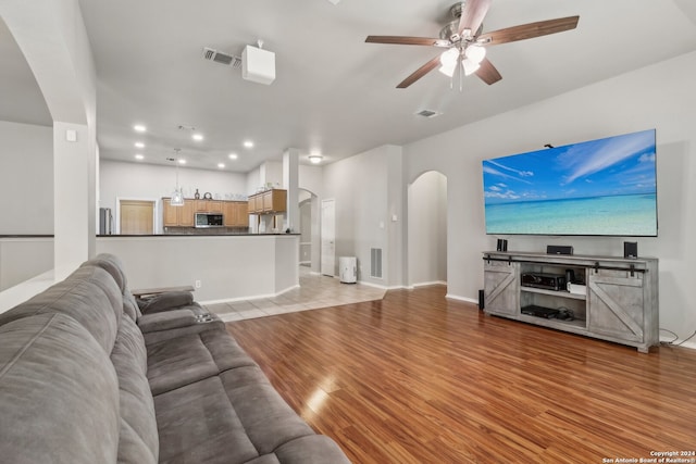 living room with light wood-type flooring and ceiling fan