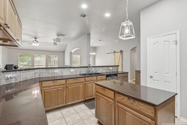 kitchen with arched walkways, a kitchen island, ceiling fan, dishwasher, and a sink