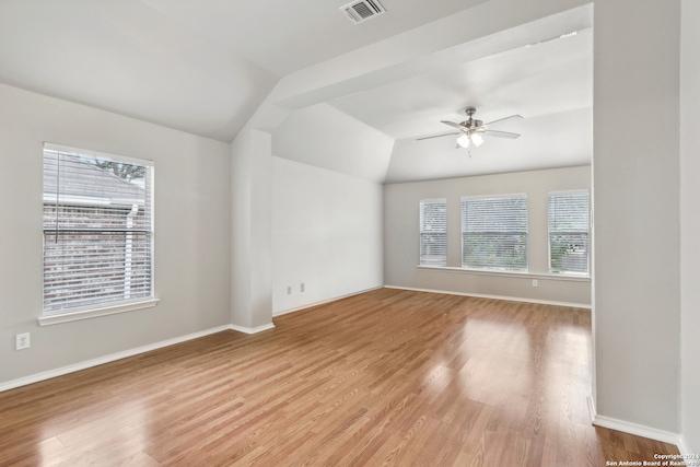 spare room featuring lofted ceiling, light wood-type flooring, and ceiling fan