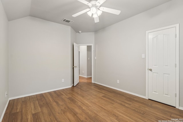 unfurnished bedroom with lofted ceiling, hardwood / wood-style floors, and ceiling fan