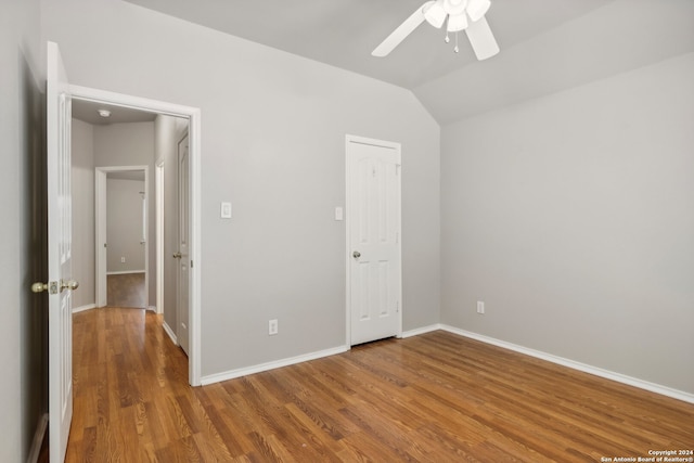 unfurnished bedroom with ceiling fan, lofted ceiling, and hardwood / wood-style floors