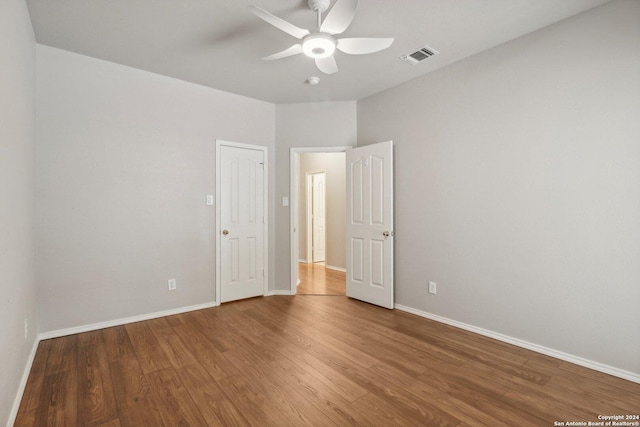 unfurnished bedroom with baseboards, visible vents, wood finished floors, and ceiling fan