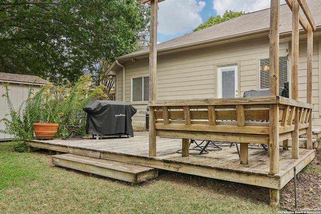 deck with a grill, a storage unit, and an outdoor structure