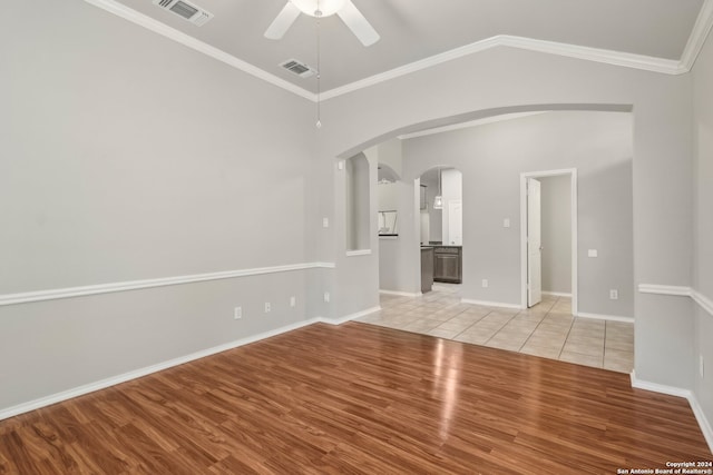 spare room with light hardwood / wood-style floors, crown molding, and lofted ceiling