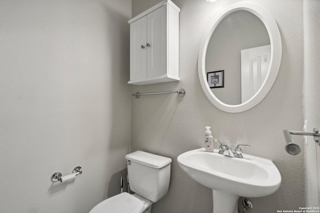 half bathroom featuring toilet and a sink
