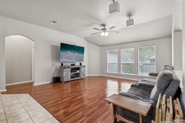 living room with ceiling fan, light wood-type flooring, and vaulted ceiling