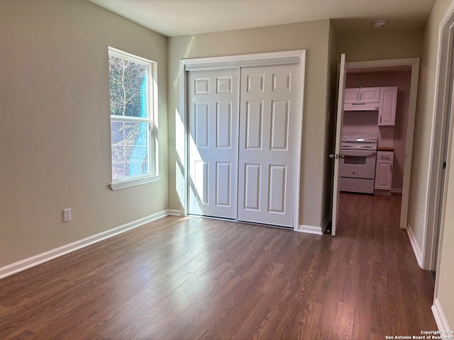 unfurnished bedroom featuring a closet and dark hardwood / wood-style flooring