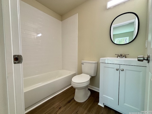 full bathroom featuring vanity, hardwood / wood-style floors, tiled shower / bath combo, and toilet