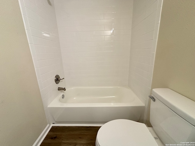 bathroom featuring toilet, tiled shower / bath combo, and wood-type flooring