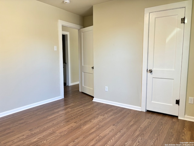 unfurnished bedroom with dark hardwood / wood-style flooring