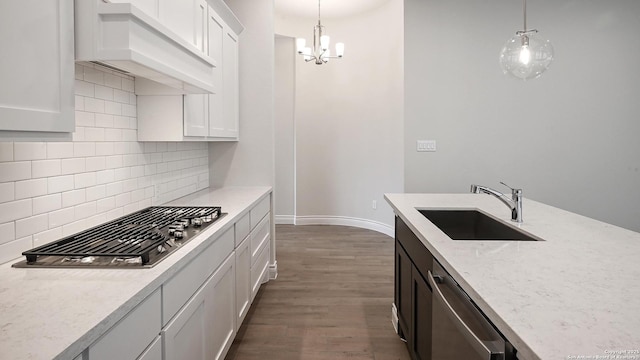 kitchen with pendant lighting, sink, white cabinets, and appliances with stainless steel finishes